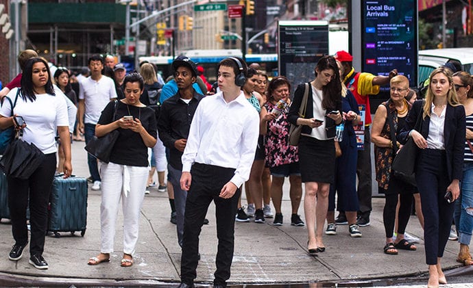 busy group of people on the sidewalk at a city intersection